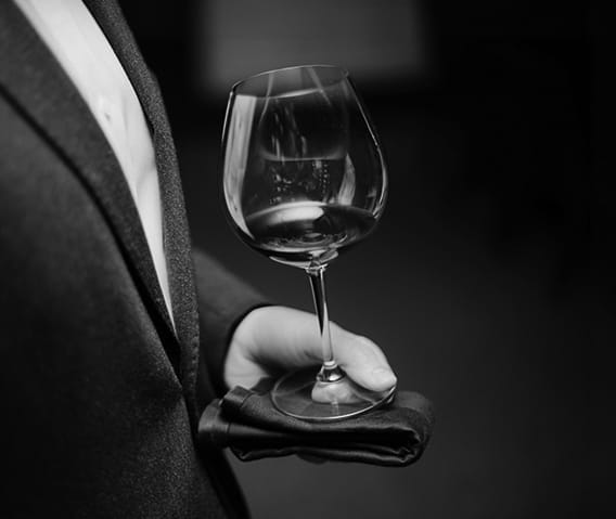 A glass of red wine being served by a sommelier at The Little Nell