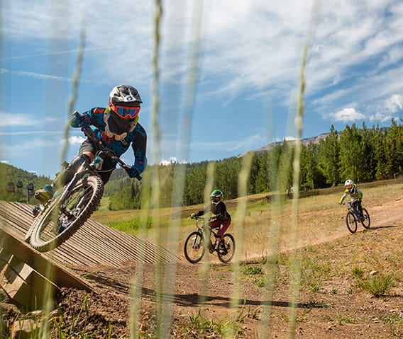 Youth mountain bikers riding in the Snowmass Bike Park.