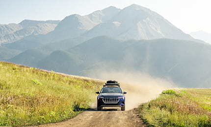 A Little Nell adventure car driving on a dirt road on top of Aspen Mountain.