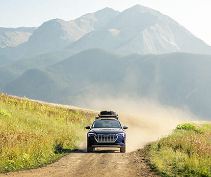 A Little Nell adventure car driving down a dirt road on top of Aspen Mountain.