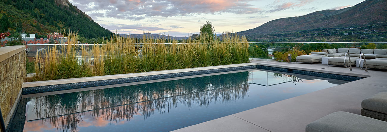 The rooftop pool at The Residences at The Little Nell in the summer at sunset.