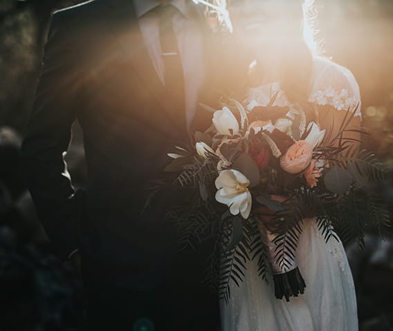 A sillouhette of a bride and groom with a bouquet.