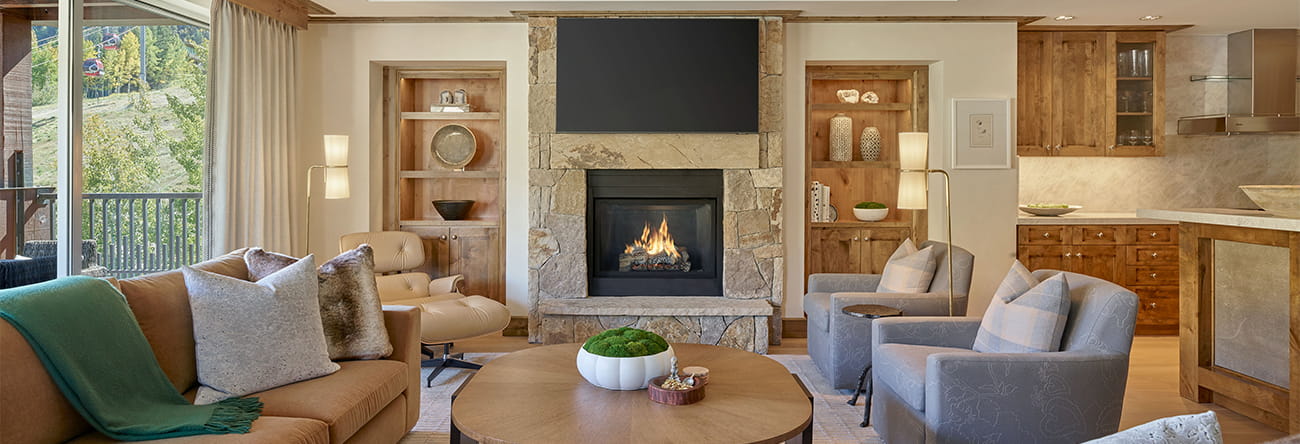 The living room of a Residence at The Little Nell with cozy seating arrangements and fireplace. 
