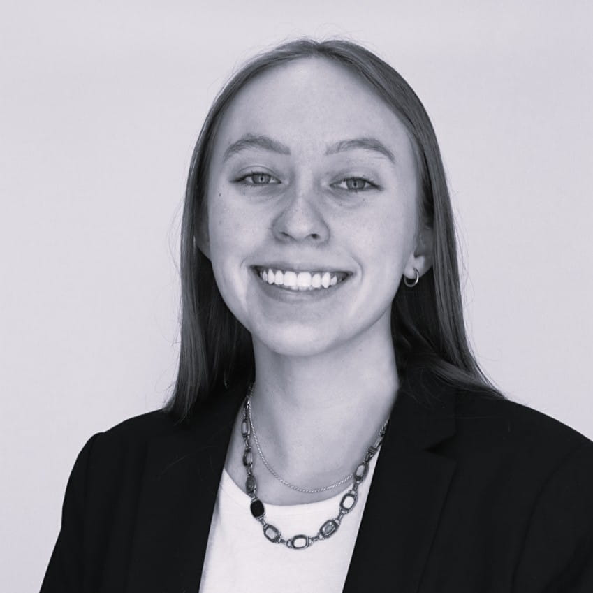 Head shot of a woman in a black blazer and necklace