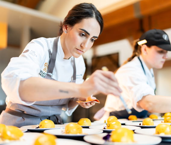 Pastry chefs plating an intricate dish.
