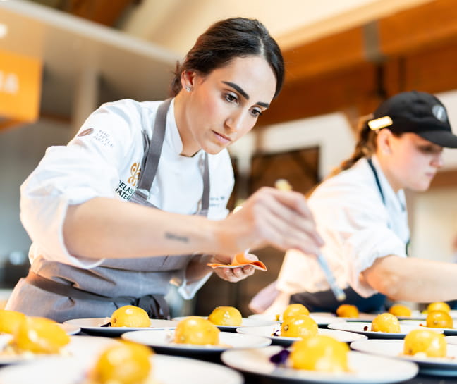 Pastry chefs plating an intricate dish.