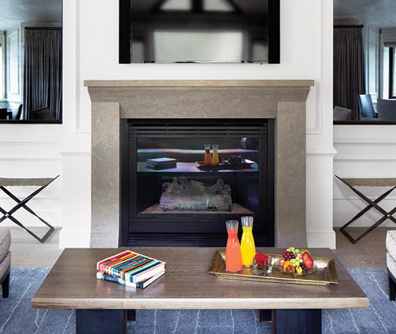 Comfortable seating area with two chairs and a fireplace in The Little Nell's Paepcke Suite.