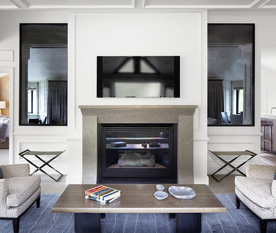 The Paepcke Suite's luxurious living area featuring a cozy gas log fireplace and a flatscreen tv.