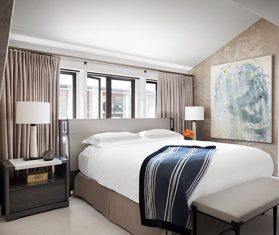 King bed with down comforter and pillows in the bedroom of The Little Nell's Paepcke Suite.