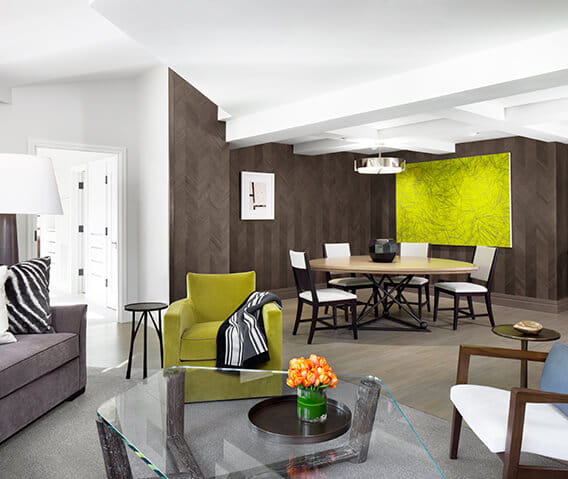 The Pfeifer suite's livingroom featuring sleek designs and a dining table and chair set.