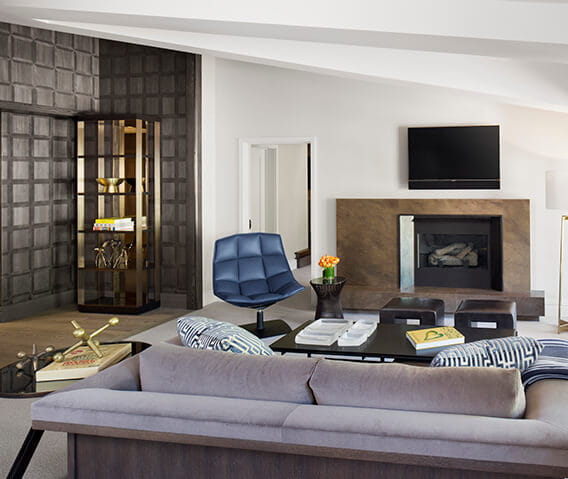 The elegant living room of The Little Nell's Roch Suite with a gas log fireplace and TV.
