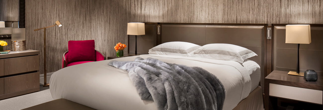 The Iselin Suite's modern and luxurious master bedroom with plush and comfy sheets and bed pillows. 