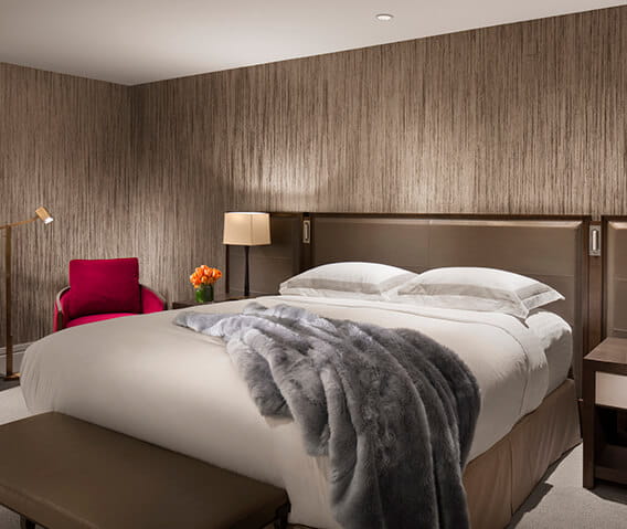 The Iselin Suite's modern and luxurious master bedroom with plush and comfy sheets and bed pillows. 