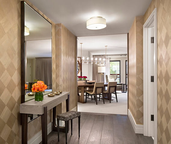 The Benedict suite's glamorous entryway with a view of the dining room table set and balcony.