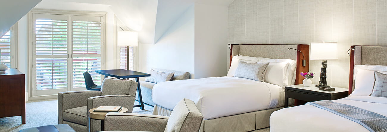 Premium mountain side guest bedroom at The Little Nell with two twin beds and a balcony.