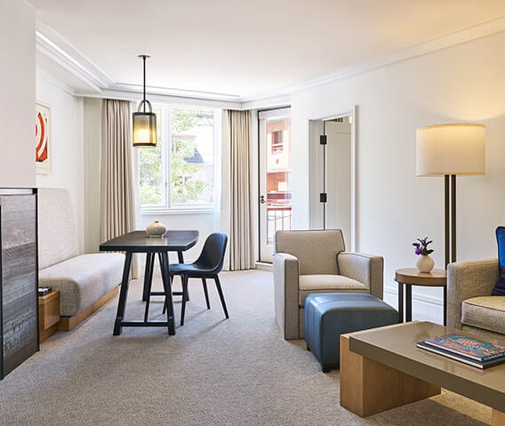 A one bedroom mountain side living area featuring ample seating and a scenic view of Aspen Mountain.