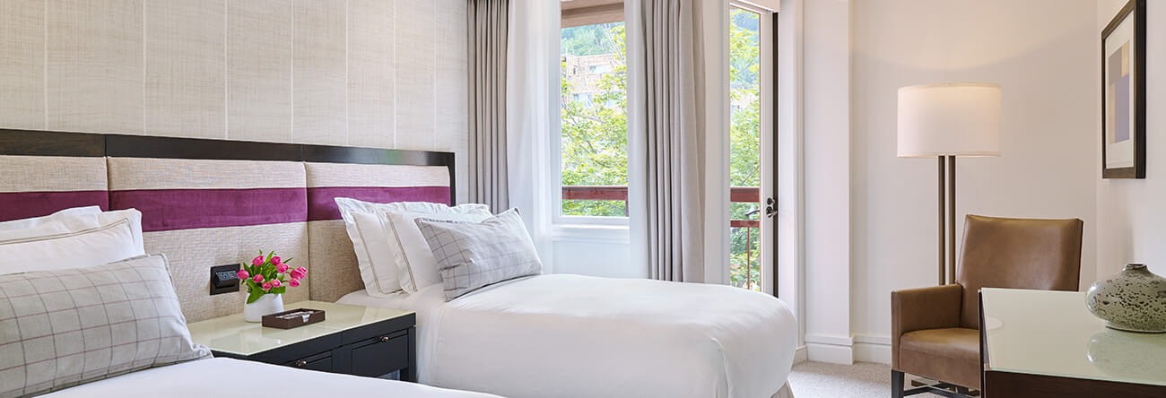 A two bedroom town side suite at a luxury 5 star hotel in Aspen, featuring two twin beds.