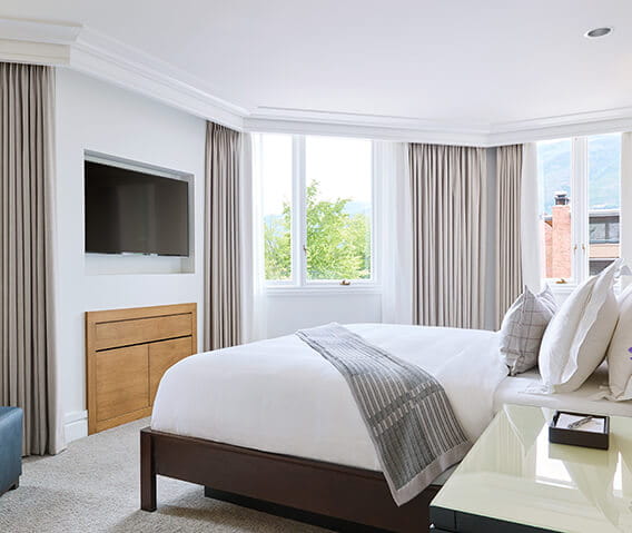 A king size bed and TV in a two bedroom town side suite at The Little Nell in Aspen.