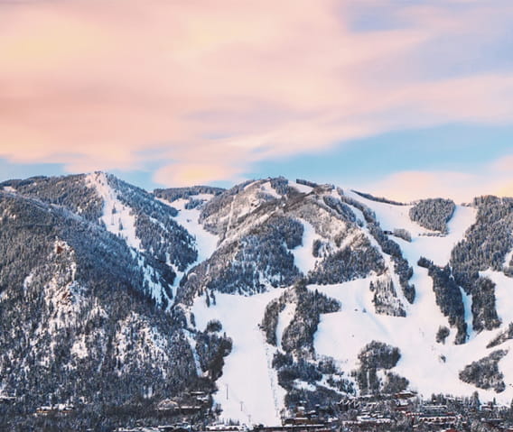 Pink clouds over Aspen Mountain during the winter with snow 