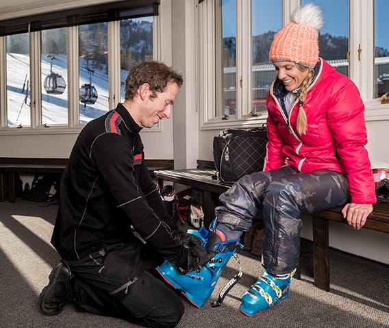 A ski concierge at The Little Nell assists a guest in fitting their ski boot rentals.
