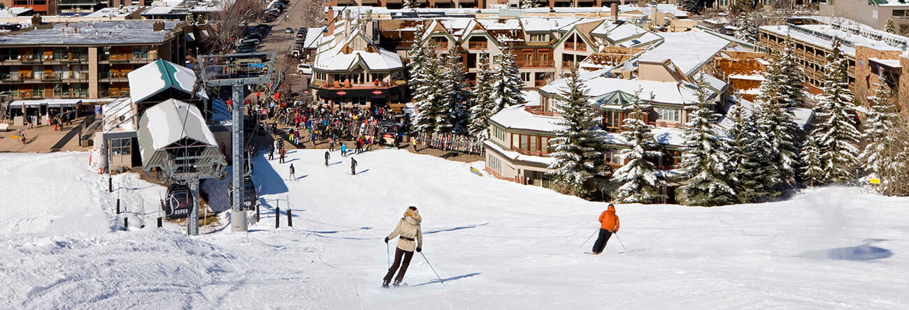 Guests skiing towards The Little Nell, Aspen's only ski-in/ski-out hotel.