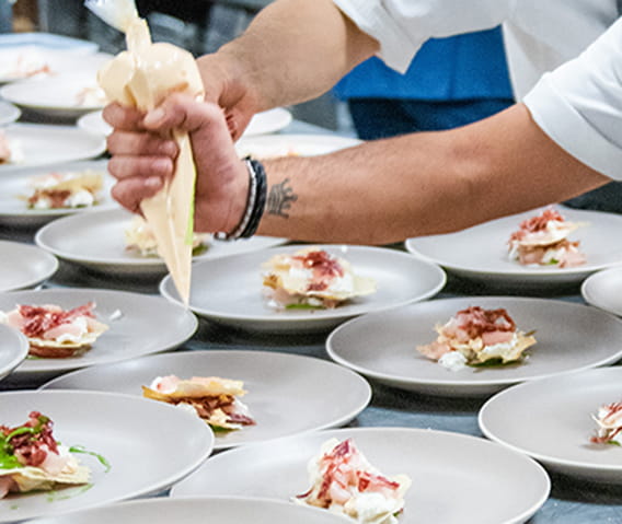 chef in element 47 kitchen decorating dish with piping bag.