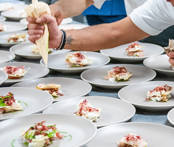 chef decorating a dish with piping bag.