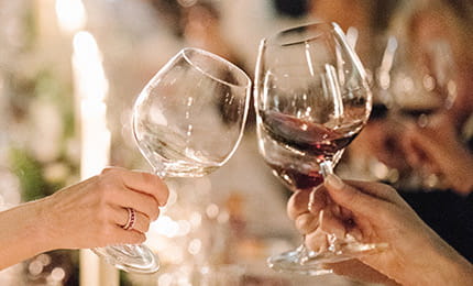 Guests at The Little Nell enjoy the award-winning wine program with glasses of red and white wine.