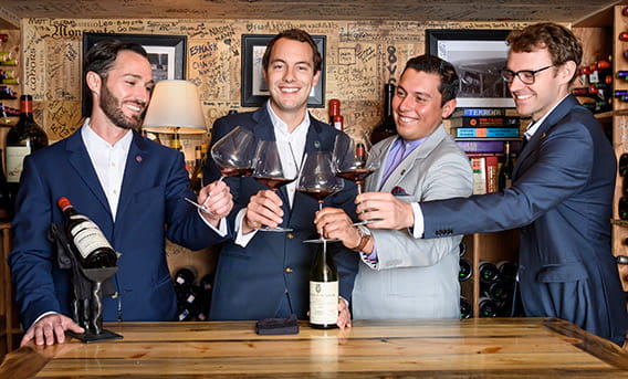 The sommeliers of The Little Nell's wine team raising a wine glass.