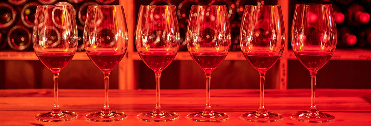 wine glasses in line on a table in the little nell's wine cellar.