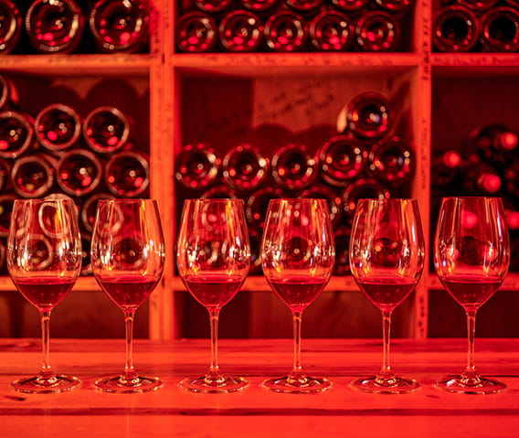 glasses of wine lined up on a table in the little nell's wine cellar