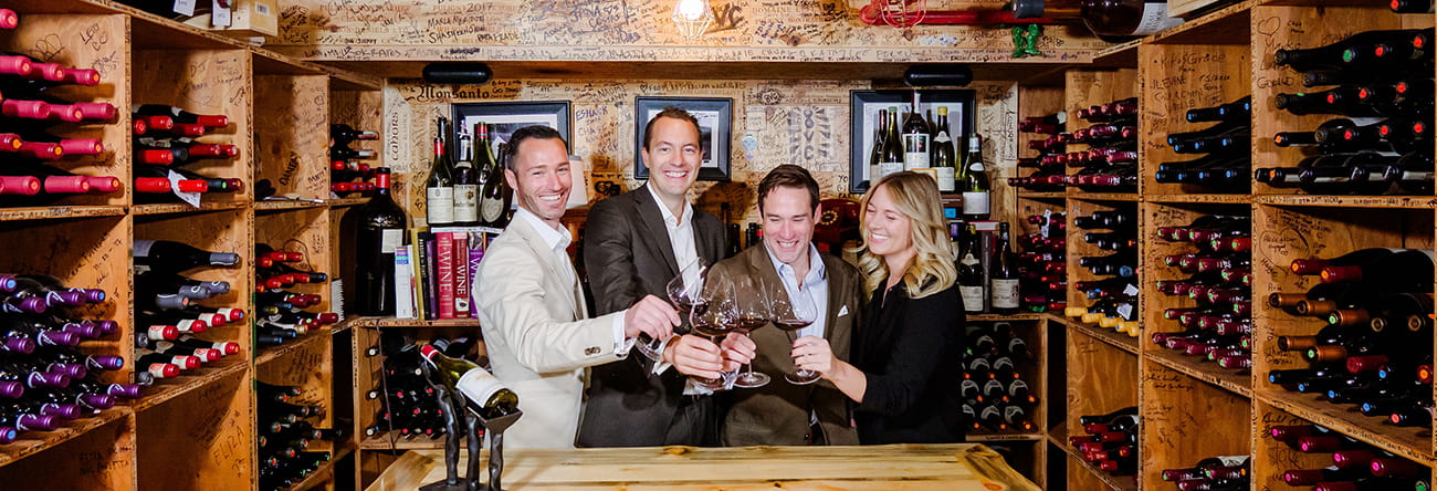 The Little Nell Sommelier Team toasting glasses of wine in The Little Nell Wine Cellar