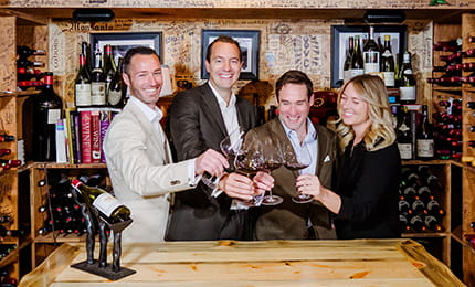 The Little Nell Sommelier Team toasting glasses of wine in The Little Nell Wine Cellar