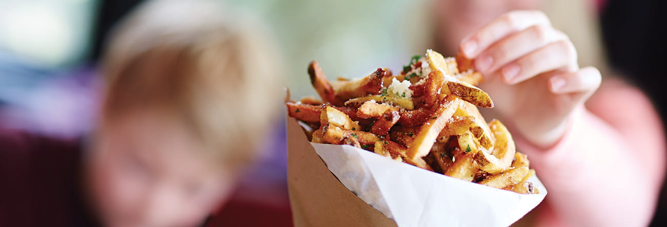 Cone of fries sprinkled with parmesan and parsley at Colorado restaurant.
