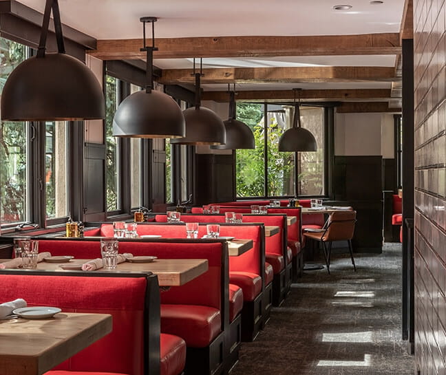 Red dining booths with table settings at AJAX Tavern.