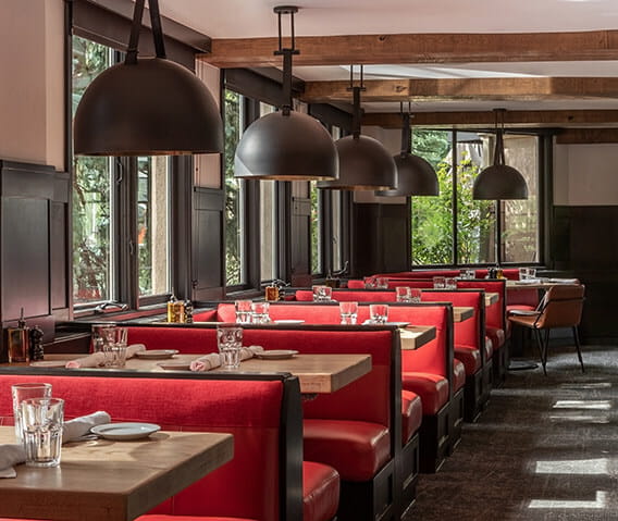 Red dining booths with table settings at AJAX Tavern.