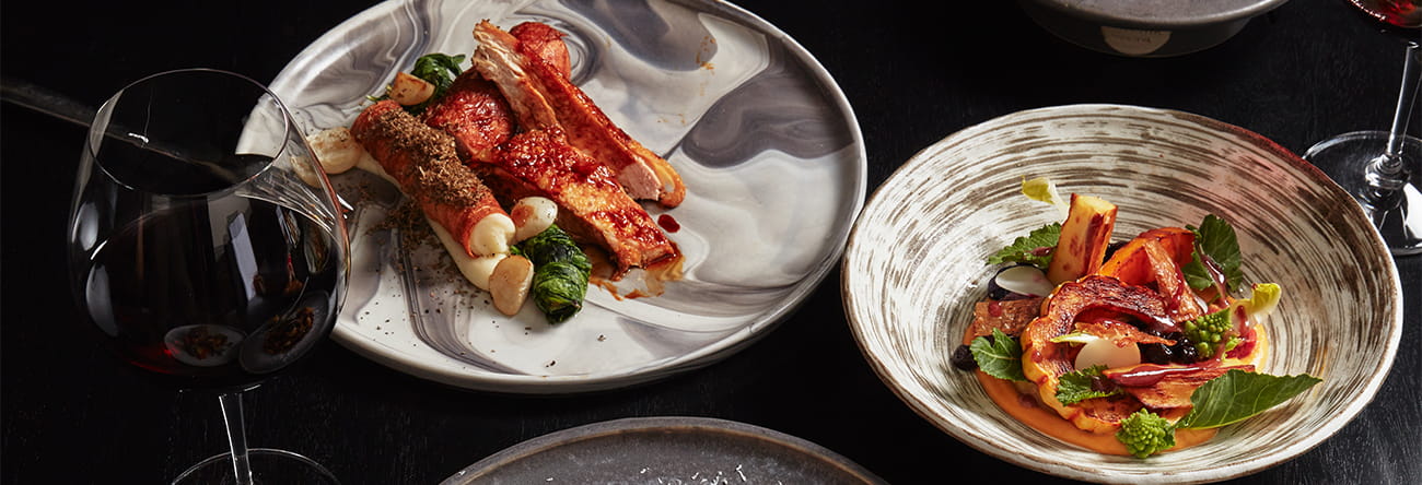 Multiple seasonal cuisines from the element 47 menu and a glass of wine.