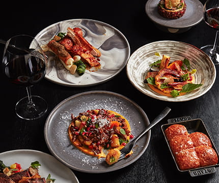 Multiple seasonal cuisines from the element 47 menu and a glass of wine.