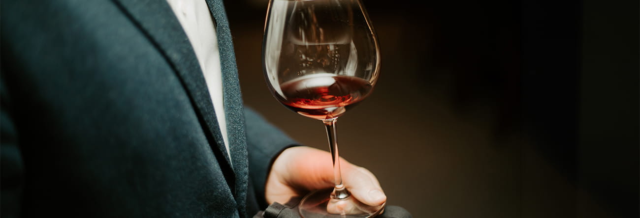 A glass of red wine being served by a sommelier at The Little Nell