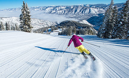 A skier skiing down the fresh tracks on Aspen Mountain.