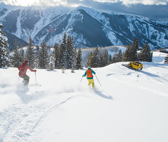 Skiers enjoying skiing down the fresh powder of Aspen Mountain.