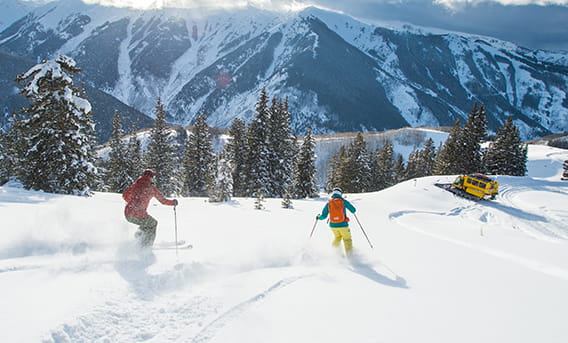 Skiers enjoying skiing down the fresh powder of Aspen Mountain.
