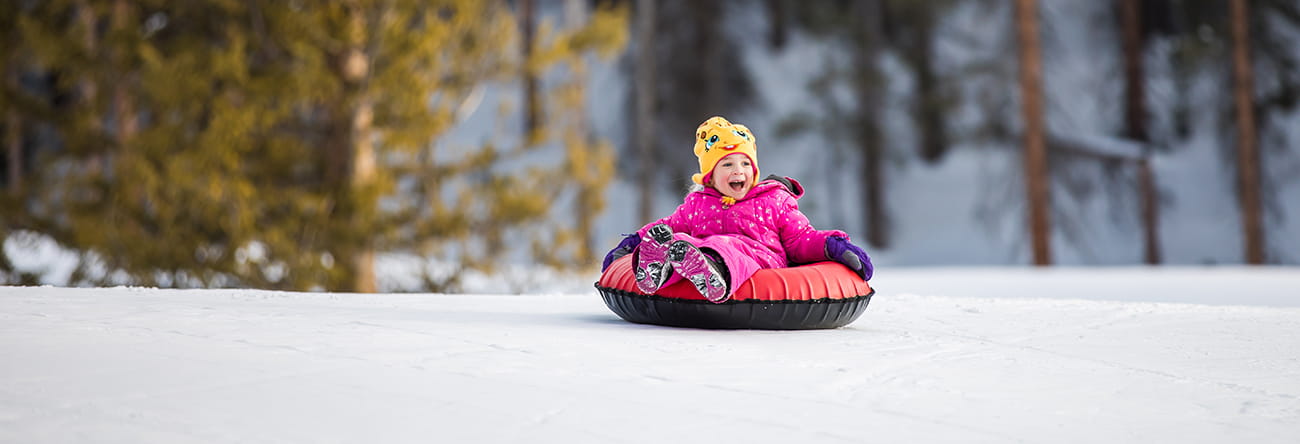 A child participates in tubing at Elk Camp on Snowmass Mountain with The Little Nell.