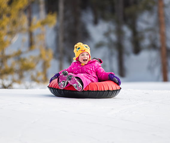A child participates in tubing at Elk Camp on Snowmass Mountain with The Little Nell.