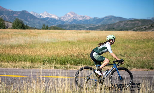 cyclist biking in front of mountains