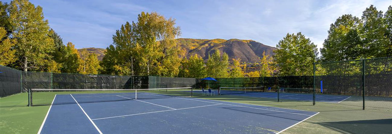 Tennis courts in Aspen with stunning mountain ranges surrounding.