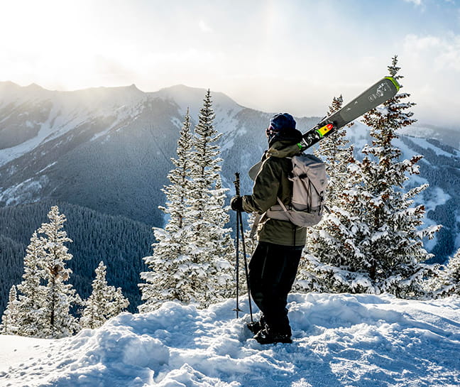 A skiier overlooking the top of a scenic mountain range. 