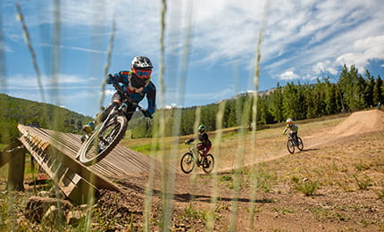 Youth mountain bikers riding in the Snowmass Bike Park.