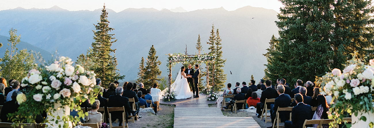 A bride and groom during a ceremony on the top of Aspen Mountain at sunset.