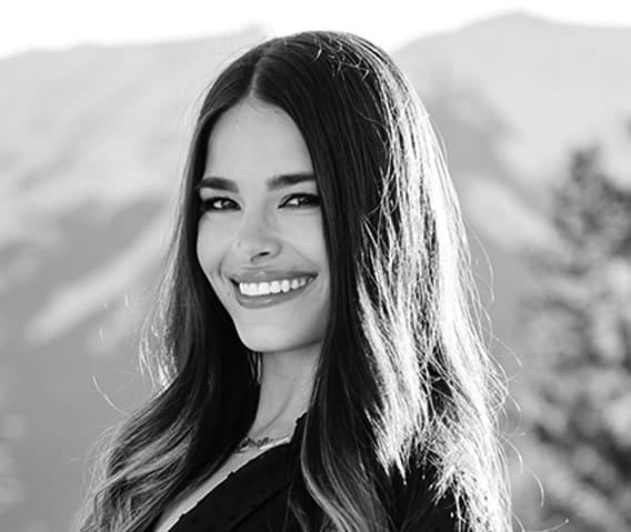 Headshot of Events Manager, Iris Berger, with mountain peaks in the background in black and white.